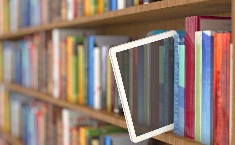 An E-reader poking out from a bookshelf