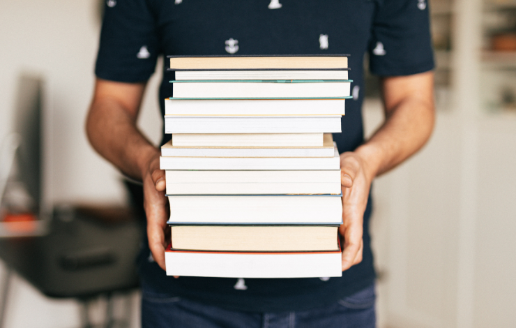Person holding a stack of books