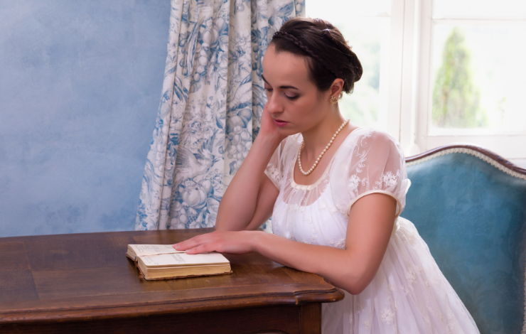 A woman in a historical dress reading a book