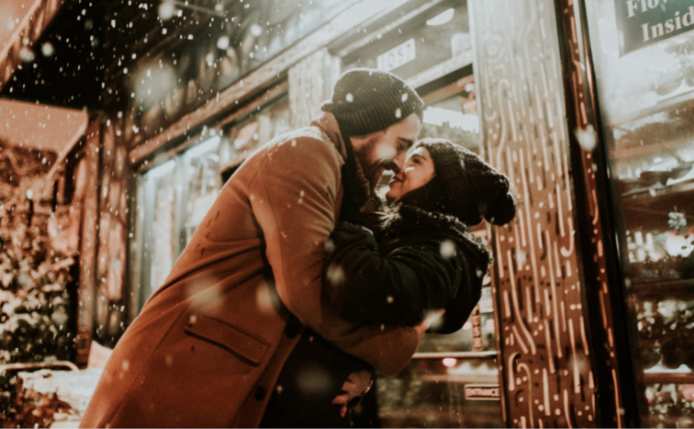 A couple going in for a kiss on a snowy night