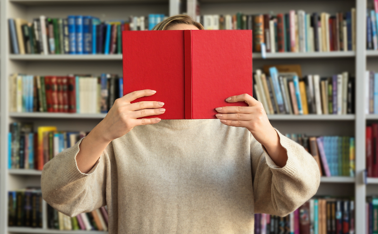 A person holding a book in front of their face