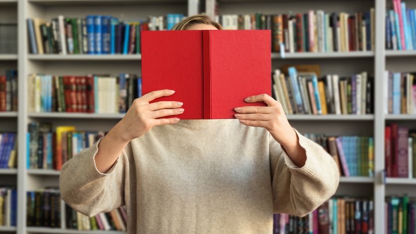 A person holding a book in front of their face