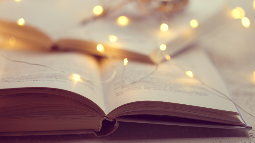 An open book with lit fairy lights on top of it