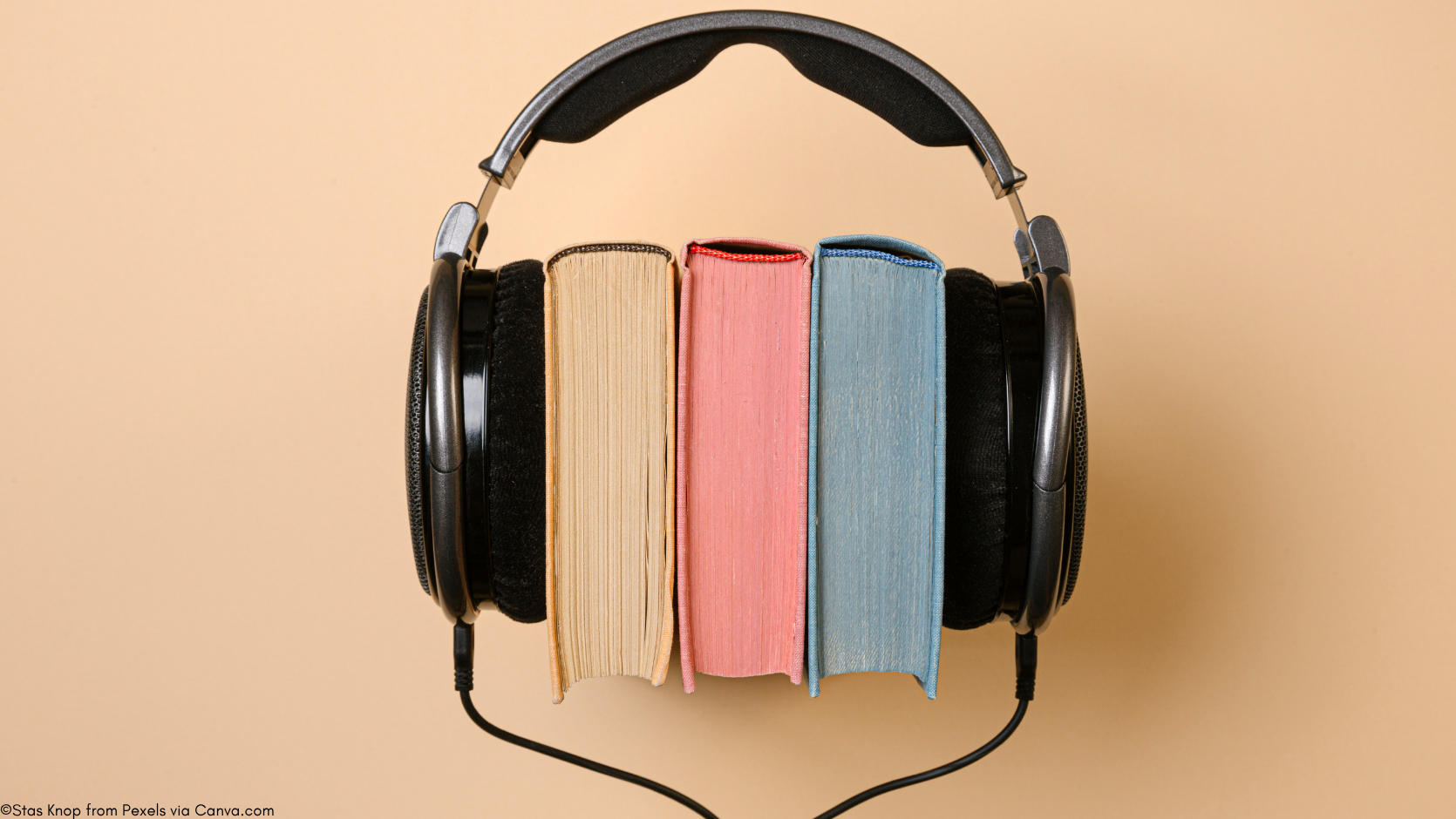 A pair of headphones around three books