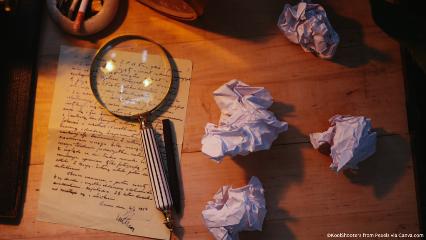 A magnifying glass over a letter on a desk