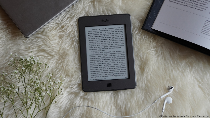 An e-reader on a faux fur throw blanket