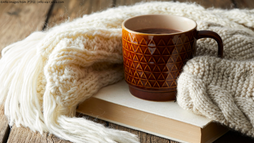 A mug on a book with a cozy blanket