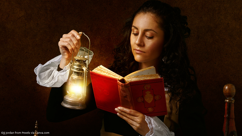 A woman in historical dress holding up a lantern to read a book
