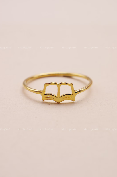 A gold book-shaped ring