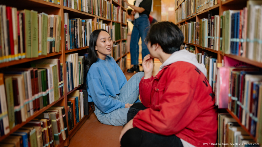 A teens sitting on the floor of the library