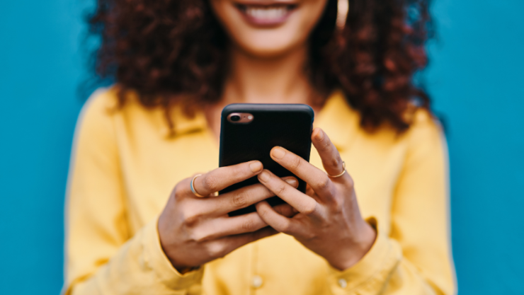 A woman holding a phone and smiling