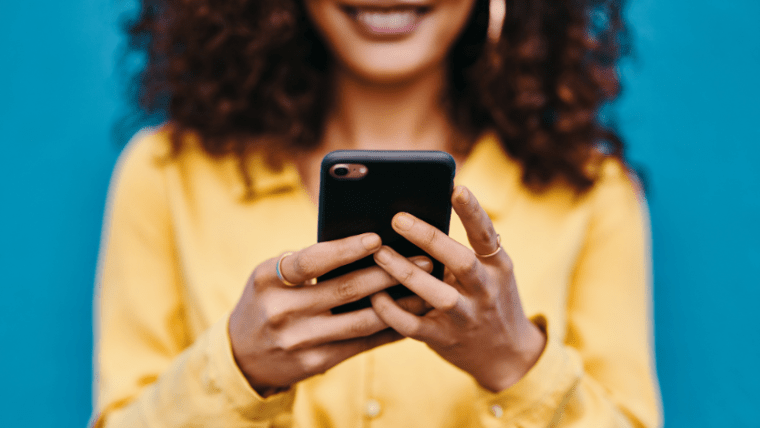 A woman holding a phone and smiling