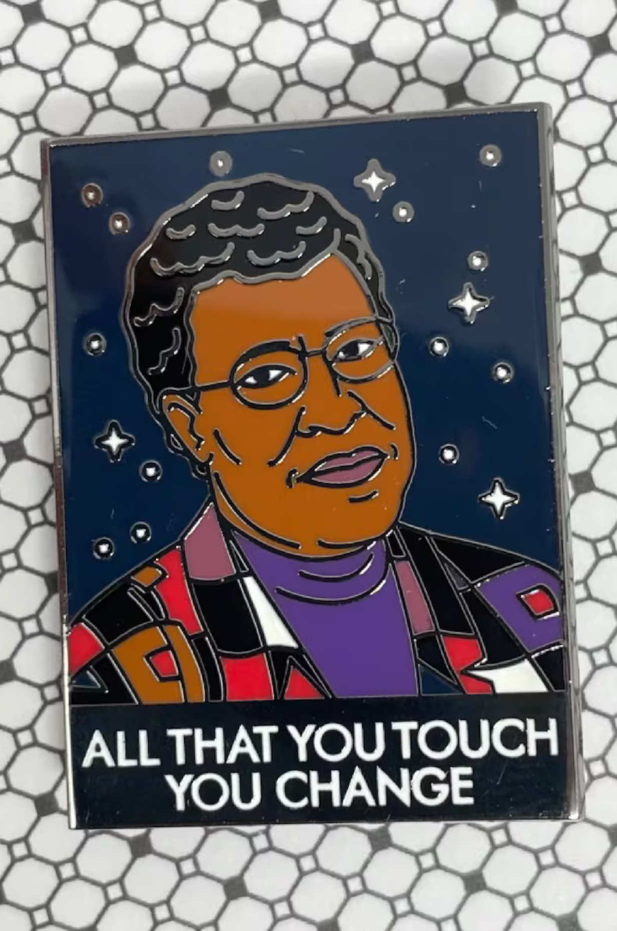 A pin with an illustration of Octavia Butler and text reading All that you touch you change