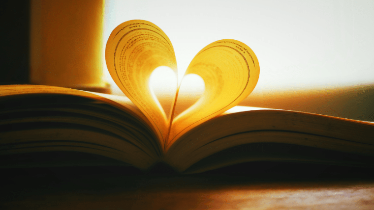 An open book with the pages folded to make a heart