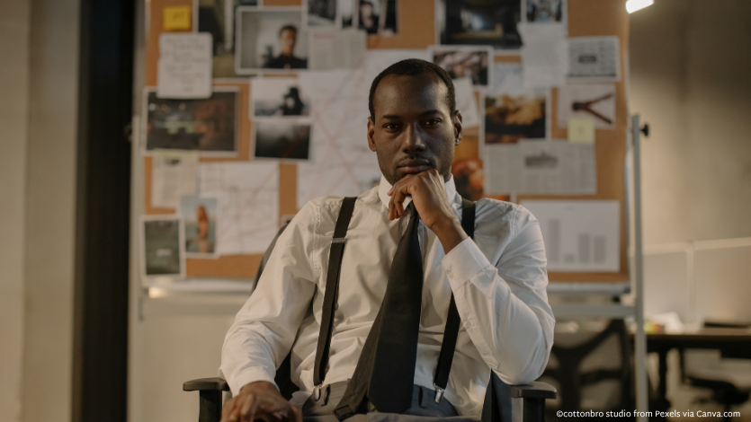 A detective sitting in front of a corkboard of clues