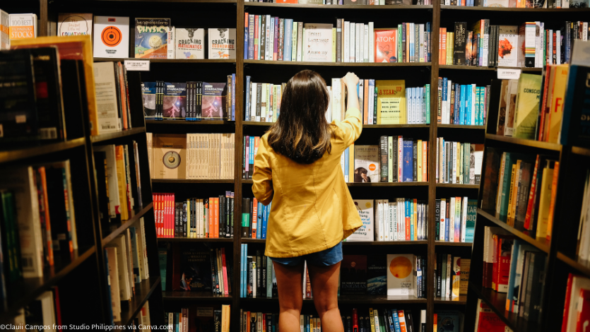 Woman reaching for book on shelf