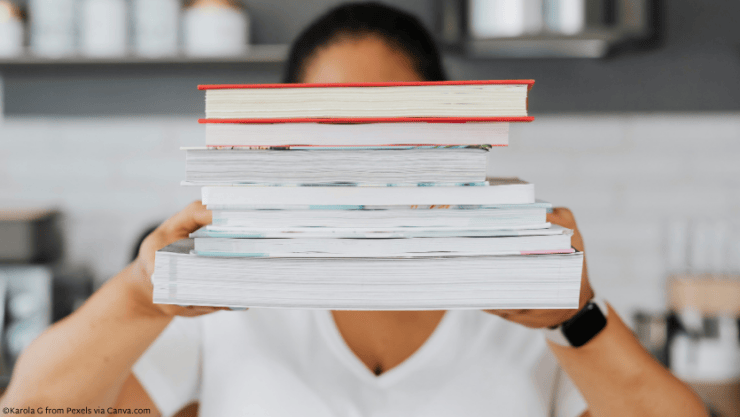 Person holding up a stack of books